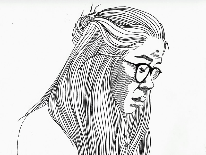 Woman with glasses and long hair looking down.